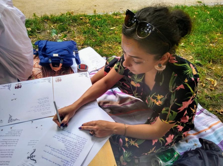 Carla Francesca Schoppel scriind într-un jurnal, în aer liber