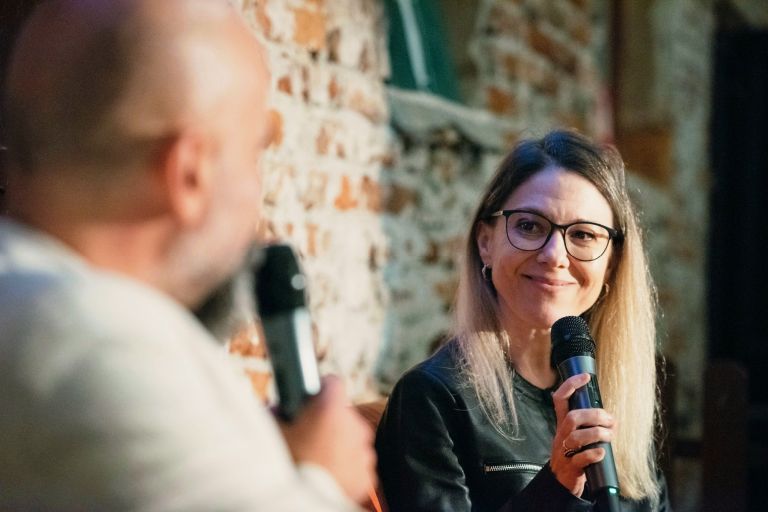 Anda Docea la un eveniment literar, vorbind la microfon